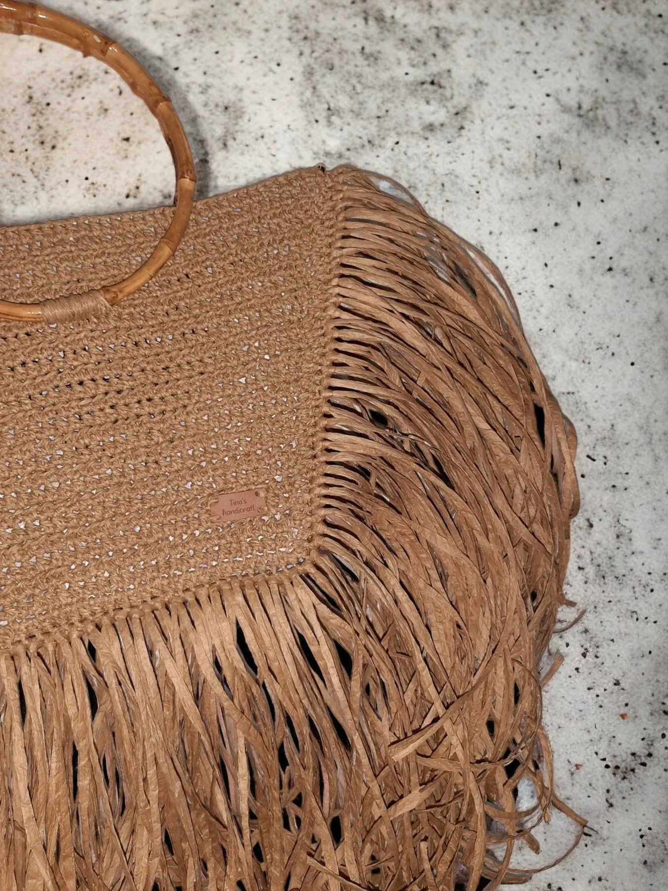 Handmade straw bag with long fringes.