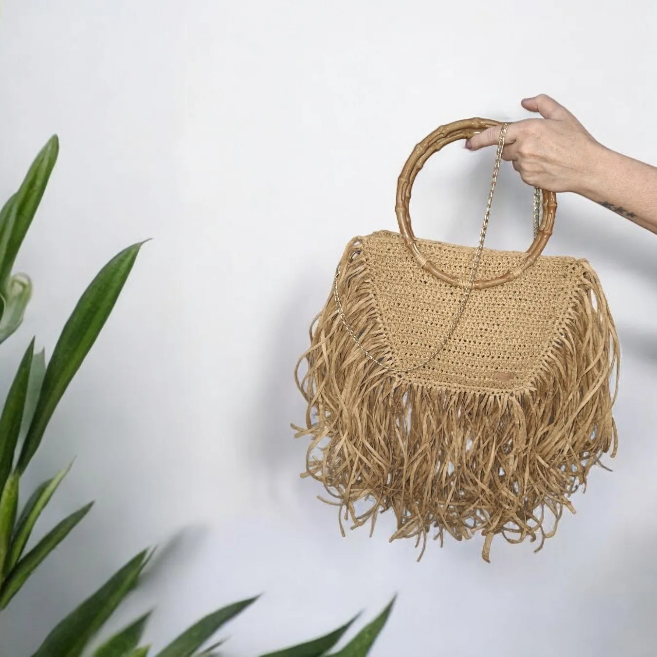 Handmade straw bag with long fringes.