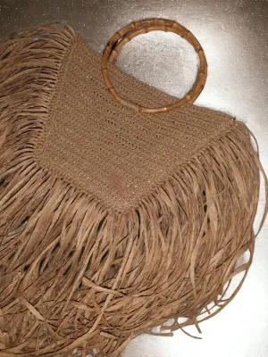 Handmade straw bag with long fringes.
