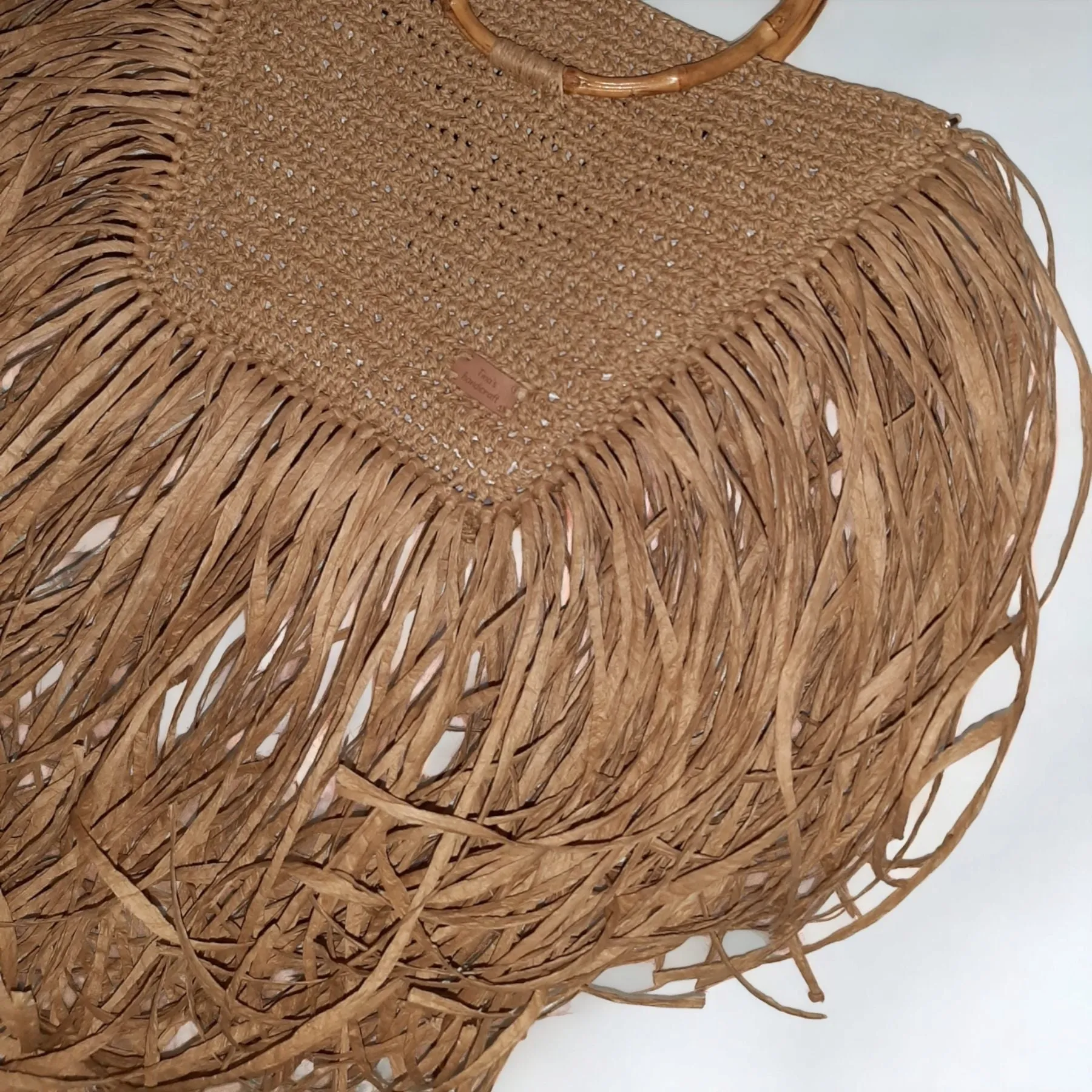 Handmade straw bag with long fringes.
