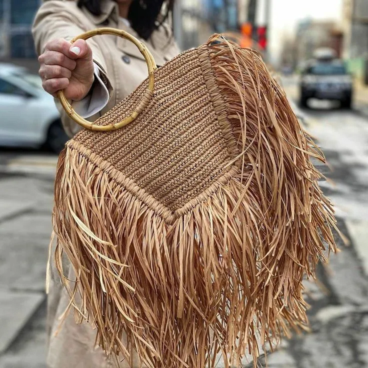 Handmade straw bag with long fringes.
