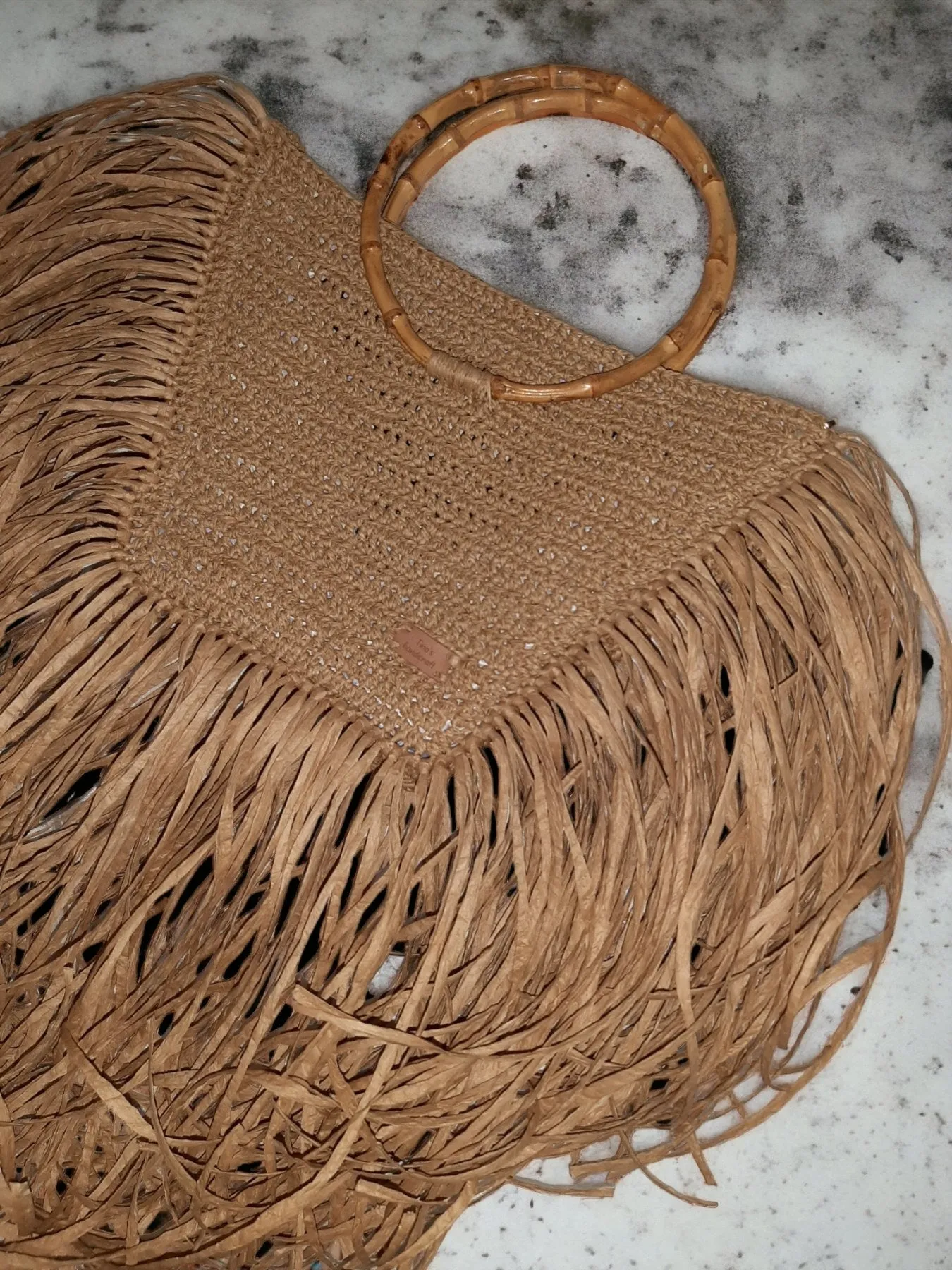 Handmade straw bag with long fringes.