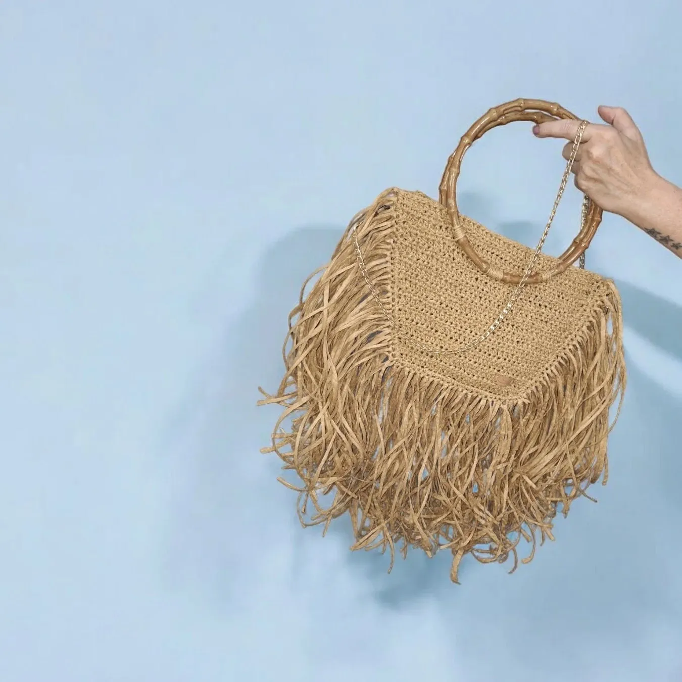 Handmade straw bag with long fringes.